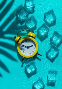 Clock and ice cubes. Vacation and daylight saving time concept. Selective f.. Stock Photos