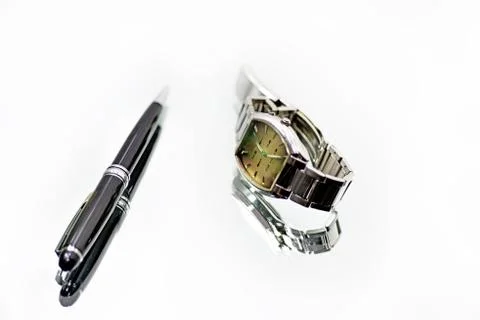 Clock and pen on mirror with reflection. Stock Photos