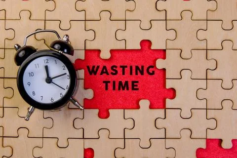 Clock and puzzle pieces represent wasting time concept Stock Photos