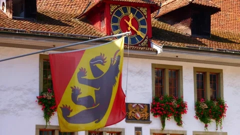 Clock and Window with Flowers and Bern Canton Flag on City Hall of Thun 動画素材 250100889