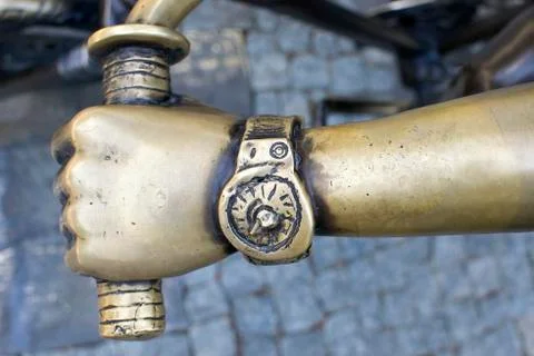 Clock on the arm of a bronze statue of a boy Stock-Fotos