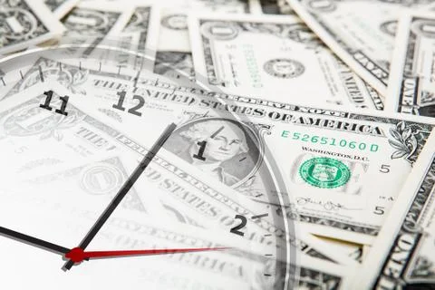 Clock on the background of banknotes dollars 库存照片