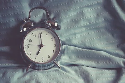 Clock on the bed in the morning. Stock-Fotos