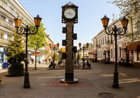 Clock between two lanterns on Sovetskaya pedestrian street in Brest Stock Photos
