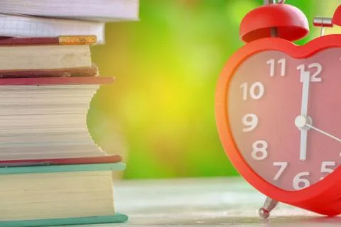 Clock with book with nature Stock Photos