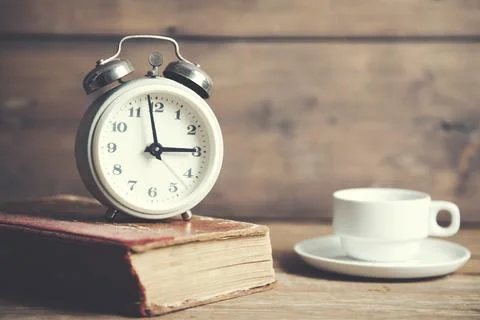 Clock on book Stock Photos