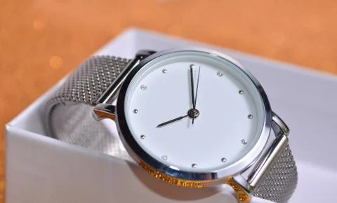 Clock in a box on a golden table. Stock Photos