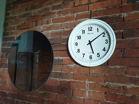 Clock in the brick wall at between mirror Stock Photos