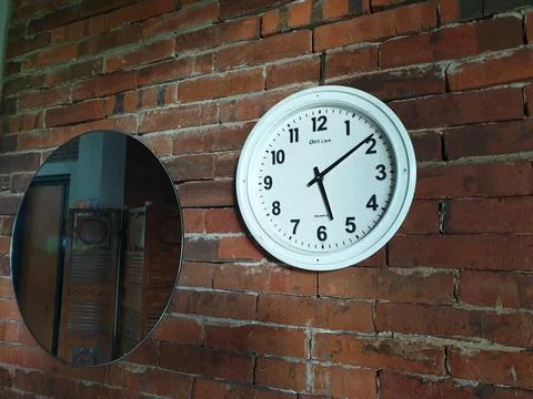 Clock in the brick wall at between mirror Stock Photos