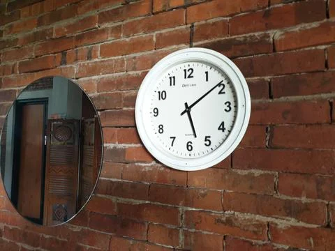 Clock in the brick wall at between mirror Stock Photos