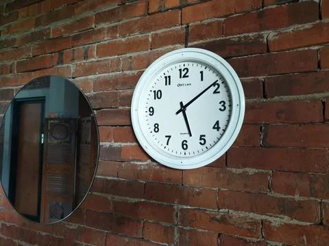 Clock in the brick wall at between mirror Stock Photos
