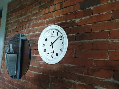 Clock in the brick wall at between mirror Stock Photos