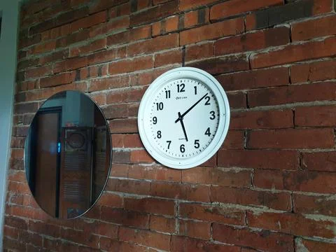 Clock in the brick wall at between mirror Stock Photos