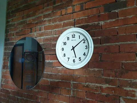 Clock in the brick wall at between mirror Stock Photos