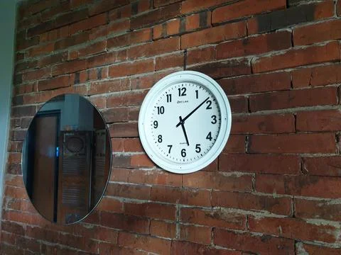 Clock in the brick wall at between mirror Stock Photos
