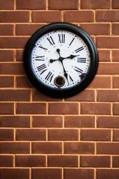 Clock on the brick wall Stock Photos