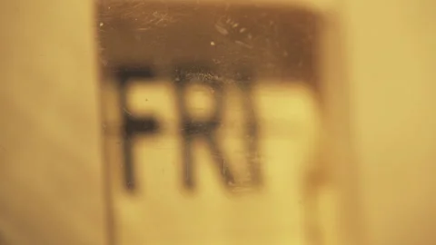 A clock changing a day of the week behind an old plastic case 動画素材 284804436