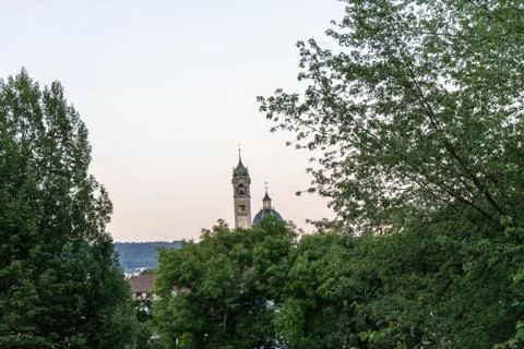 Clock church tower seen through tree at sunset blue hour Stock Photos