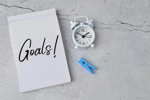 Clock, clothespin and notebook written with text GOALS!. Foto stock