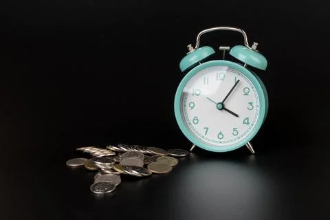 Clock with coins on black background.The concept of increasing profitability Stock Photos