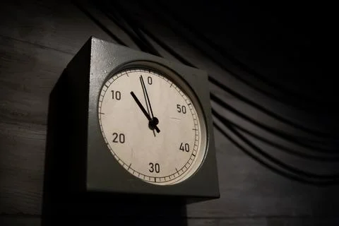 Clock Displaying Time Approaching Zero in a Dimly Lit Room Emphasizing Urgency Stock Photos