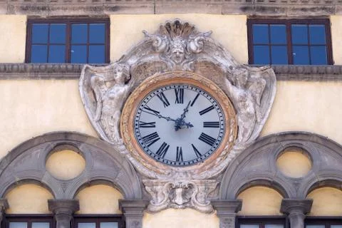 Clock on facade of ancient palace in Lucca, Italy Stock Photos