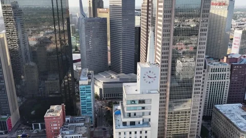 Clock face and mirrored glass towers in the downtown Dallas core aerial drone Stock Footage 342501400