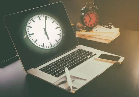 Clock face on computer screen travel office table Stock Photos