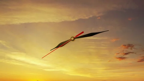 Clock face hands against sunset orange sky with clouds 스톡 동영상 329955098