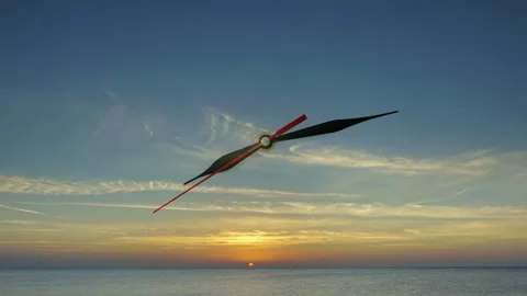 Clock face hands against sunset orange sky with clouds 스톡 동영상 330305532