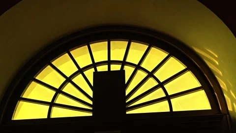A clock face is visible in the middle of a window Stock Footage 346783619