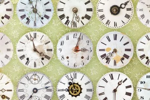 Clock faces in front of retro wallpaper Foto stock