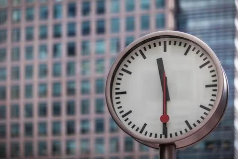 Clock in front of office block Stock Photos