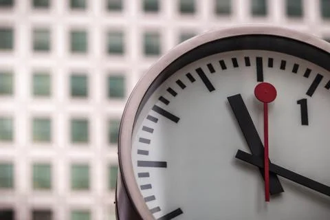 Clock in front of office block Stock Photos