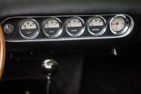 Clock, fuel level and thermometer on a vintage car's dashboard Stock Photos
