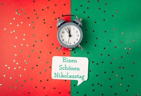 A clock on a green background with a white message that says Happy St. Nicholas Stock-Fotos