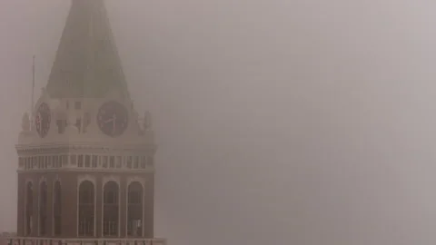 The clock hand spinning on a church or building tower on a foggy day in Stock Footage 235760673