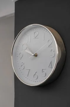 Clock with handles decorating a black wall Foto stock
