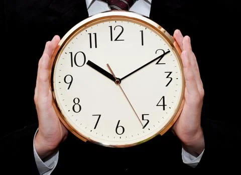 Clock in hands of businessman Stock Photos