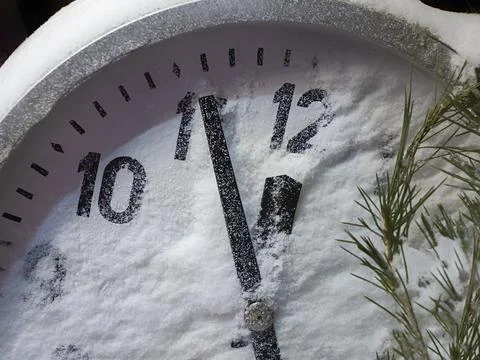 Clock hands go to midnight, the New Year, the dial is covered with snow Stock Photos