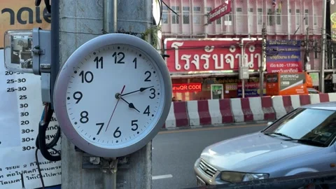 Clock hanging traffic on road downtown and pawn shop building. Time, Bangkok Stock Footage 230960862