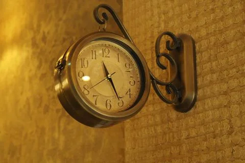 Clock hanging on wall in indoor setting Stock Photos