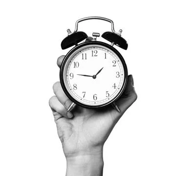 Clock held in a hand showing time against a white background Stock Photos