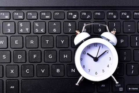 Clock on keyboard concept for time management and countdown to deadline Foto stock