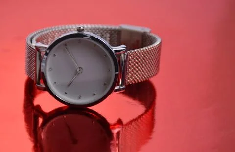 The clock lies on a red background. Stock Photos