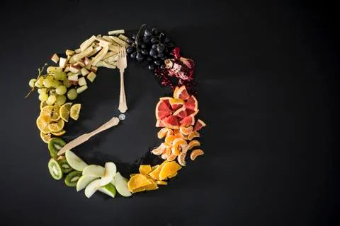 Clock made with fruit, vegetables and flatware Stock Photos