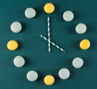 Clock made of macaroons and drinking straws Stock Photos