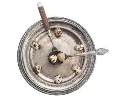 Clock made of quail eggs on silver plate with fork and spoon, isolated on whi Stock Photos