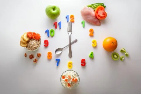 Clock made of spoon and fork. Schedule of proper nutrition. Stock Photos