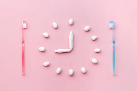 Clock made of toothpaste with toothbrushes. Oral care and dental hygiene concept Stock Photos
